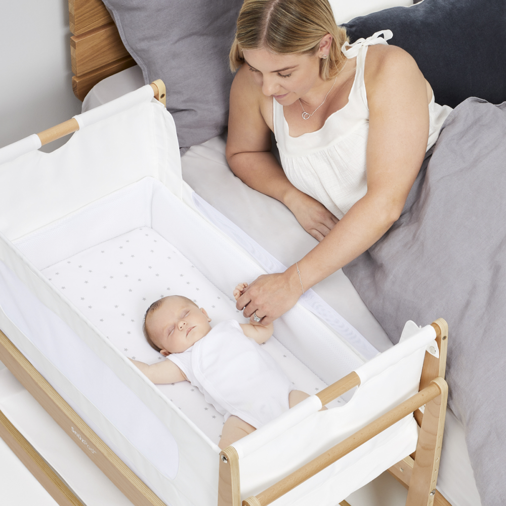 Mother interacting with baby in SnuzPod 4 Bedside Crib - Natural
