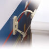 Close-up view of Mommy's Helper Anti-Tip Furniture Safety Strap installed between a wall and a dresser, preventing tipping.