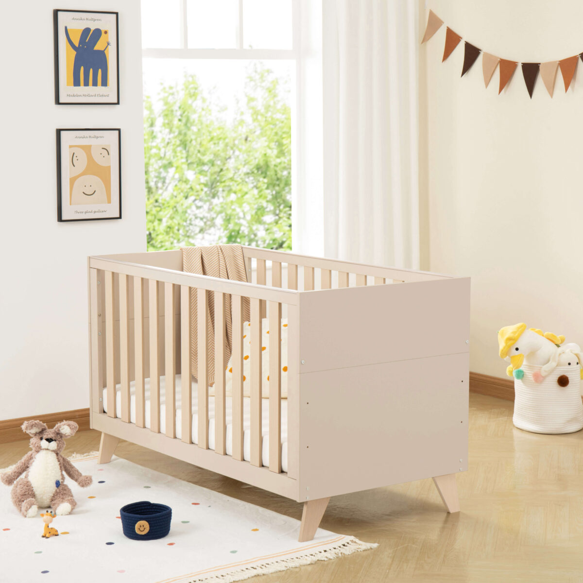 Stylish Babymore Dante Cot Bed in cashmere with soft bedding in a modern nursery setting.