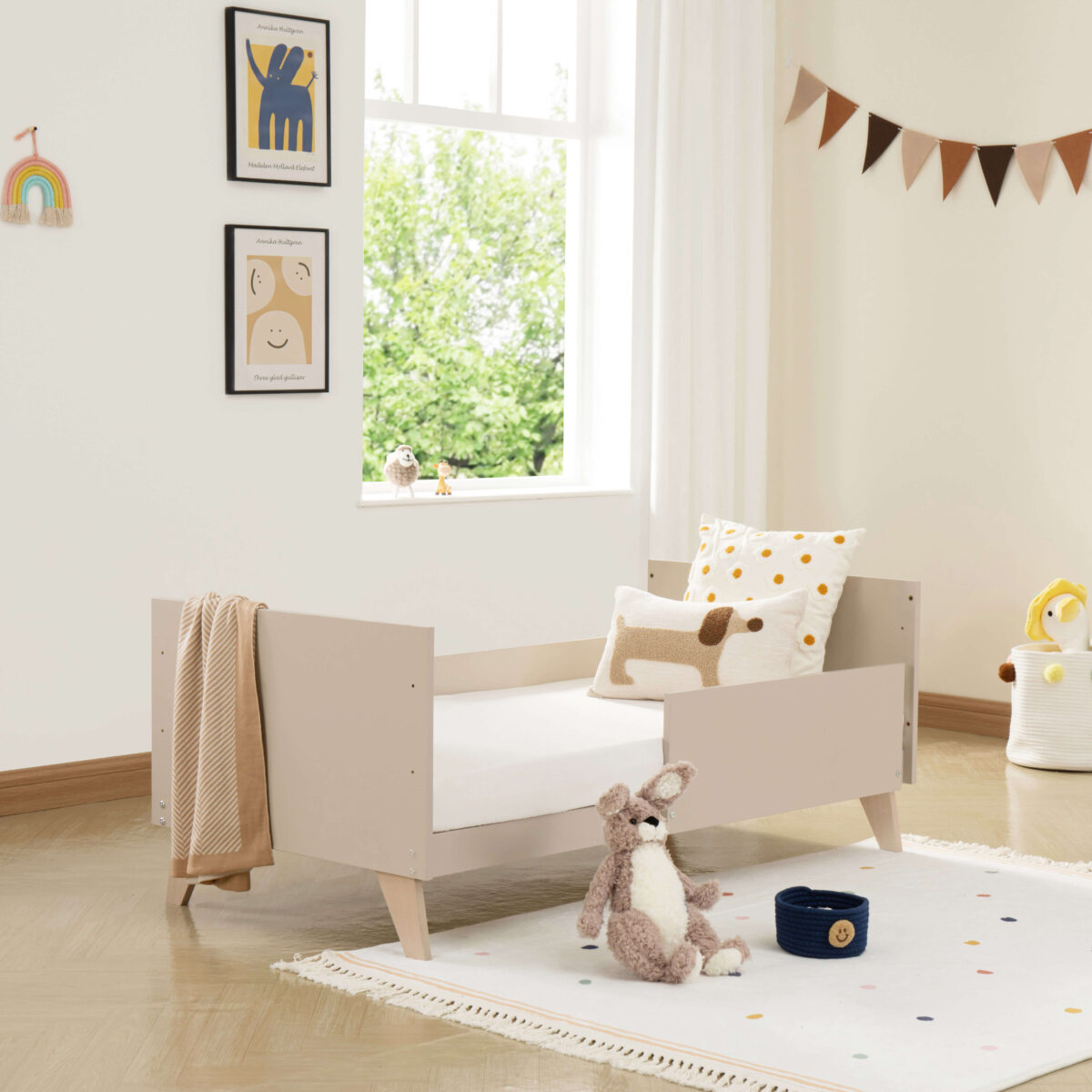 Babymore Dante Cot Bed converted into a toddler bed with soft furnishings in a cozy room.