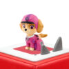 Skye from PAW Patrol in pink outfit on top of a red Toniebox against a white background.