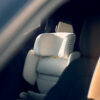 Close-up view of an empty AXKID Up High Back Booster Car Seat installed in the backseat of a car.