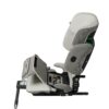 Side view of Axkid Up booster seat in beige with open seat panel revealing storage and instructions.