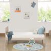 Cashmere toddler bed with blanket and toys in a cozy nursery setting.