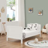 Toddler bed setup in white with panda cushions and soft natural lighting.