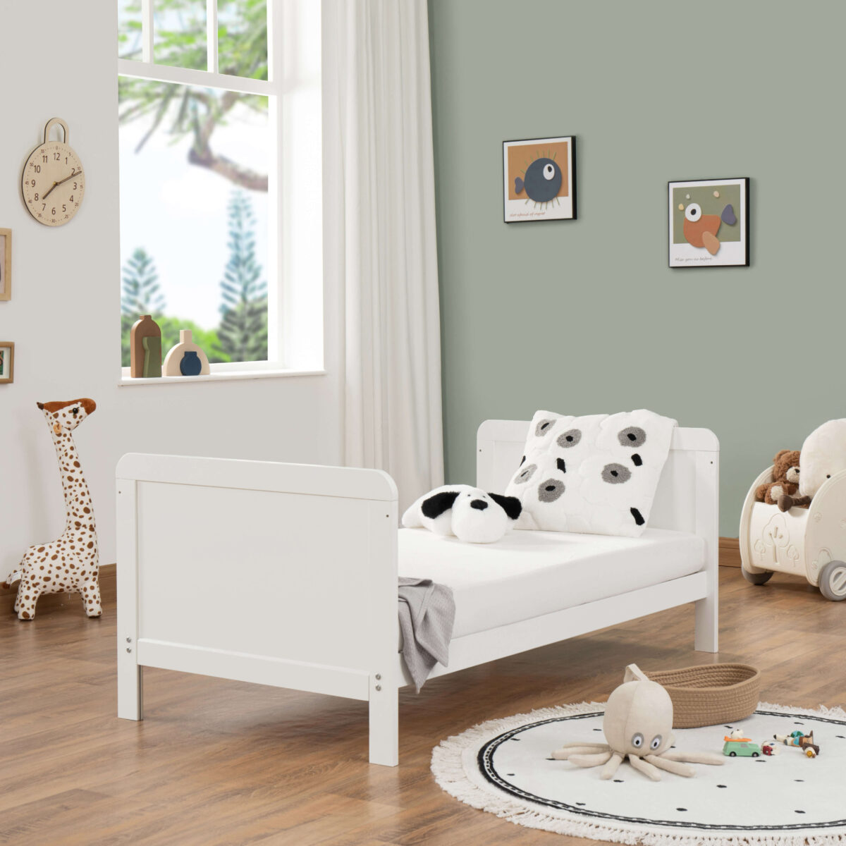 Toddler bed setup in white with panda cushions and soft natural lighting.