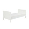 White toddler bed with low profile and smooth finish shown at an angle.