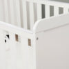 Close-up of cot bed corner showing smooth white finish and secure assembly.