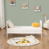 Converted cot bed to daybed with white frame, toys and wall art in background.