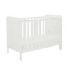 Angled view of white cot bed with slatted sides and mattress.