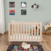 Babymore Dante Mini Cot Bed in natural wood, styled with plush toys and alphabet rug.