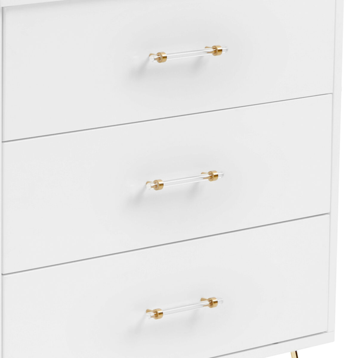 Close-up of acrylic and gold handles on a white three-drawer dresser.