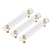 Set of three flat clear acrylic handles with gold metal mounts on a white background.