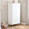 Angled view of a nursery wardrobe with gold accents, toys, and a hanging height chart.