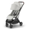 Savannah UPPAbaby MINU V3 stroller angled view with canopy extended and brown leather handlebar.