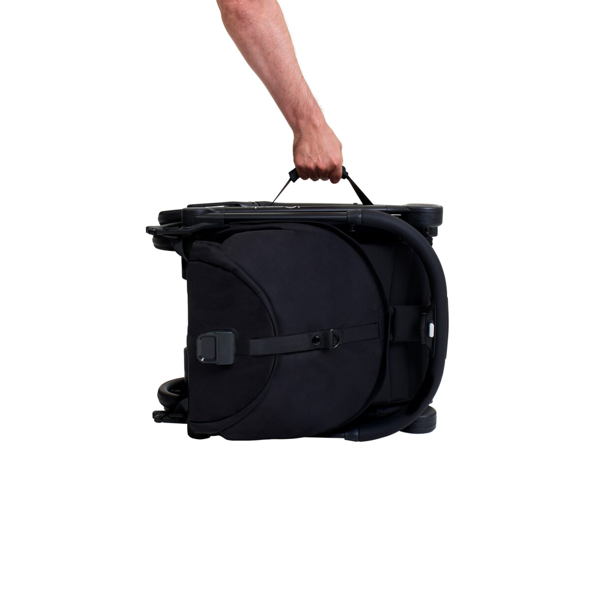 Folded iCandy stroller being carried by handle with one hand.