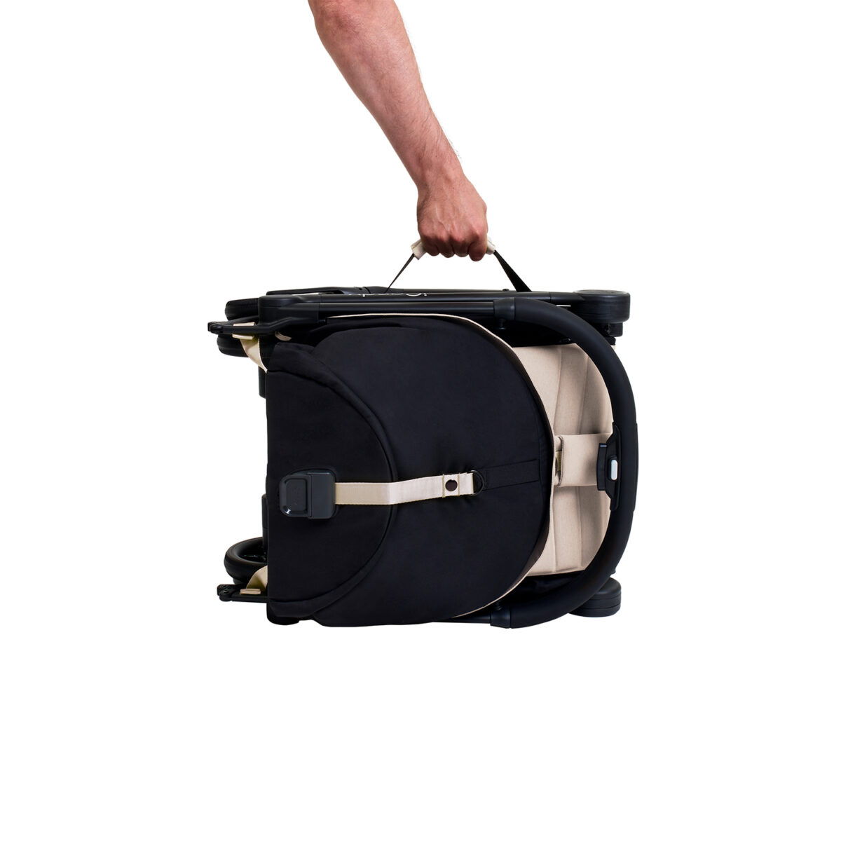Folded latte iCandy stroller being carried by handle with one hand.