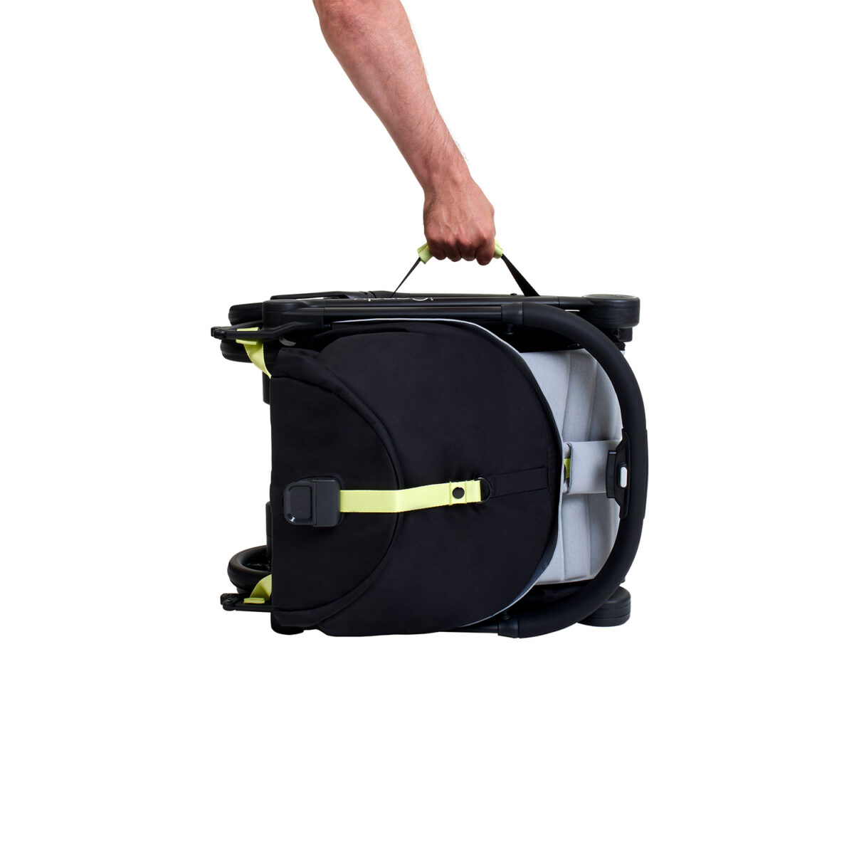 Folded iCandy stroller being carried by handle with one hand.